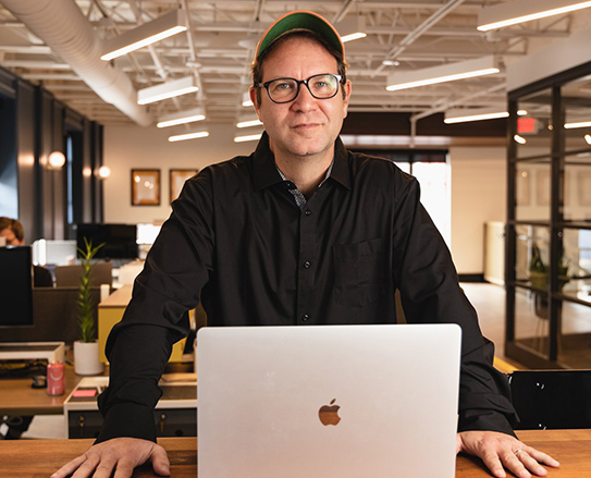 Real image of Michael Ermann, founder of The Olive Book, working behind a laptop, symbolizing his commitment to effective and engaging SAT prep.